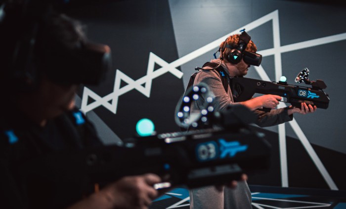 A man in a virtual reality headset looks at a screen with the words ... Hiburan konten realitas virtual